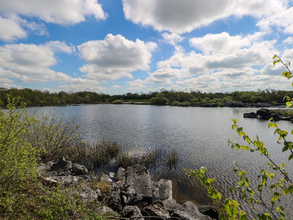 A view of a lake surrounded by trees and rocks at Cahir Cottage Ballinrobe, County Mayo
