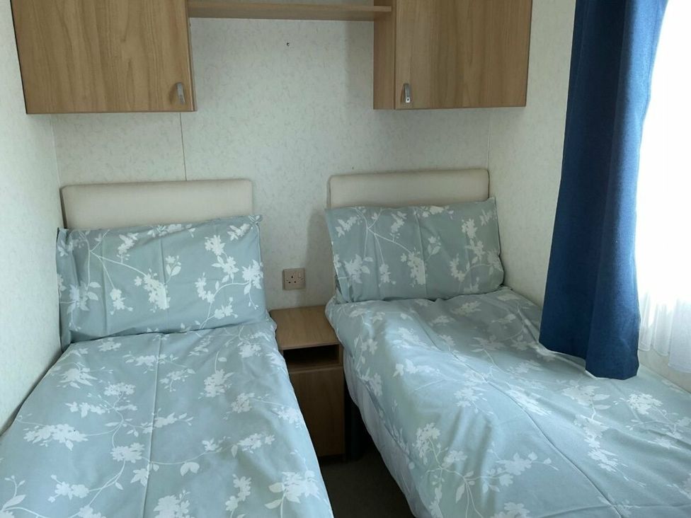 A bedroom with two beds and a shelf at St Monans Holiday Park - Holiday Accommodation 19927 Anstruther
