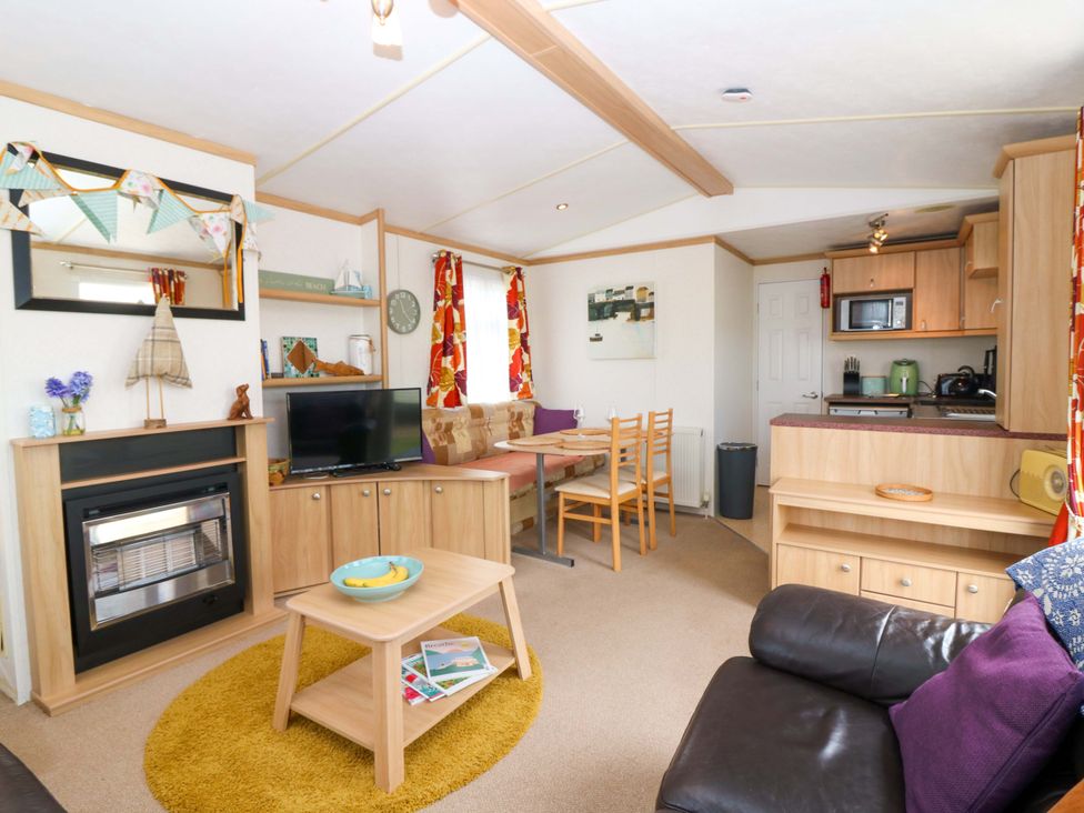 A living room with a sofa and kitchenette at St Monans Holiday Park - Holiday Accommodation 19927 St Monans