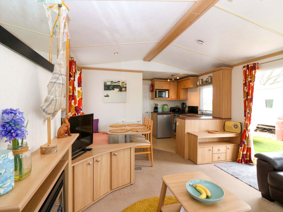 A living room with a sofa, television, and dining area at St Monans Holiday Park - Holiday Accommodation 19927, St Monans
