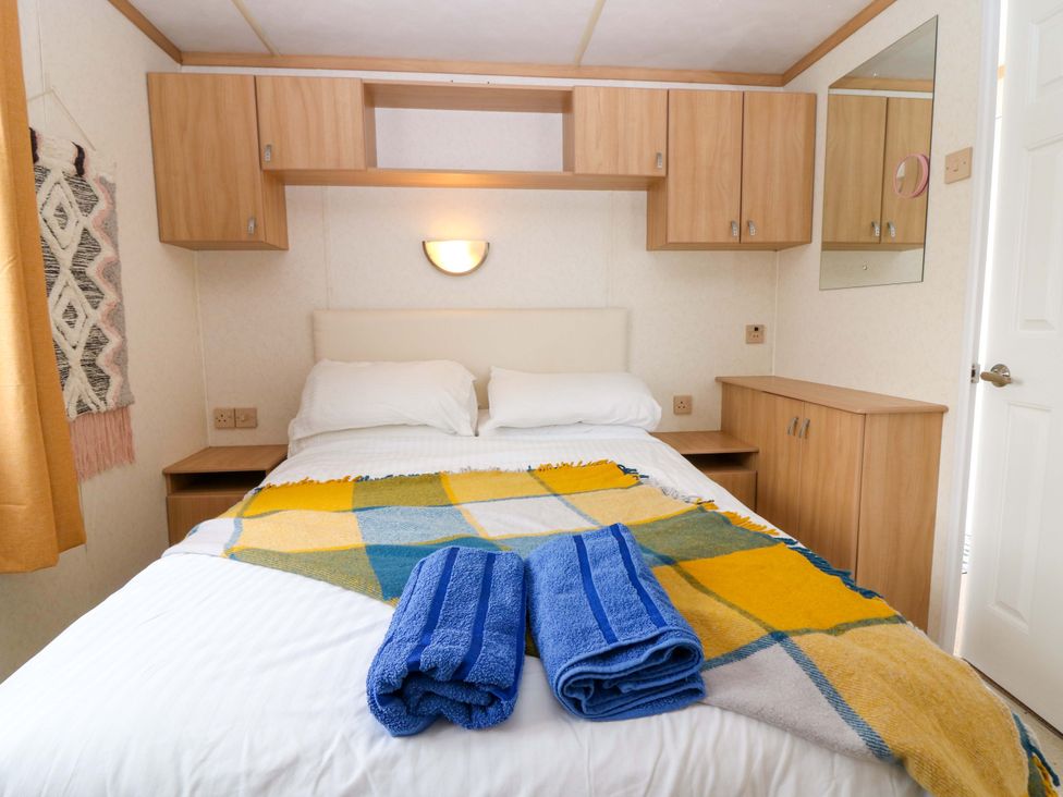 A bedroom with a bed and wooden furniture at St Monans Holiday Park - Holiday Accommodation 19927 St Monans
