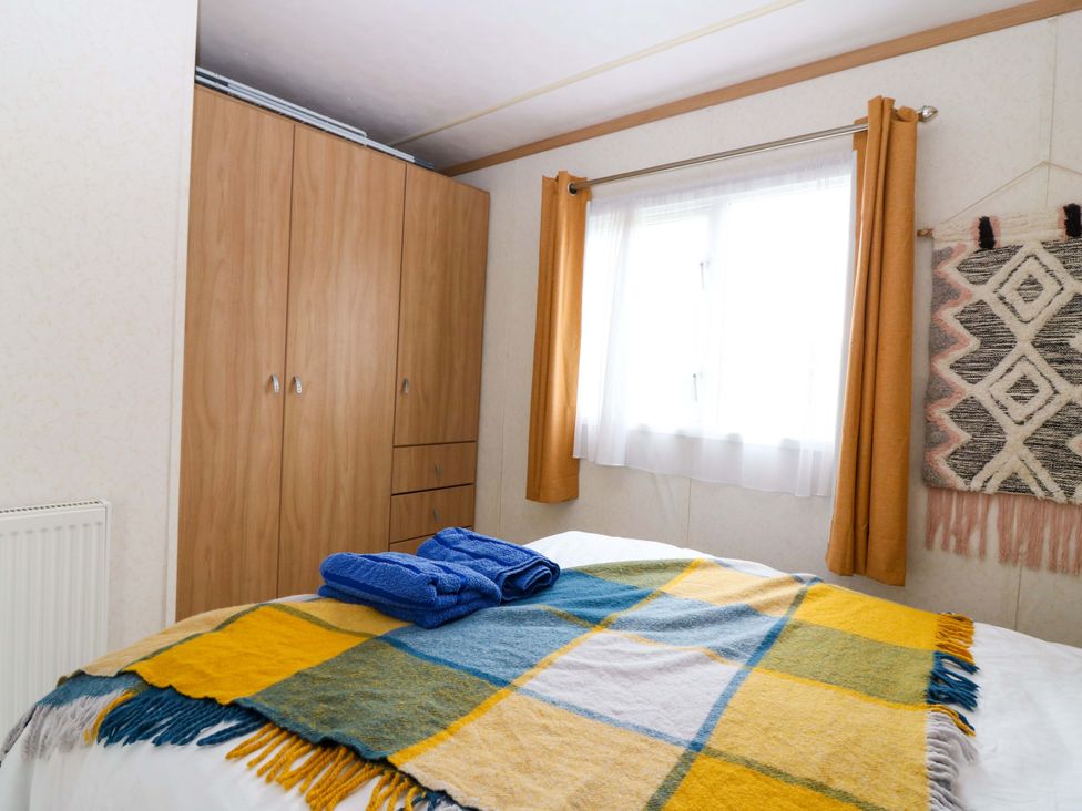 A bedroom with a bed, wardrobe, and window at St Monans Holiday Park - Holiday Accommodation 19927, St Monans