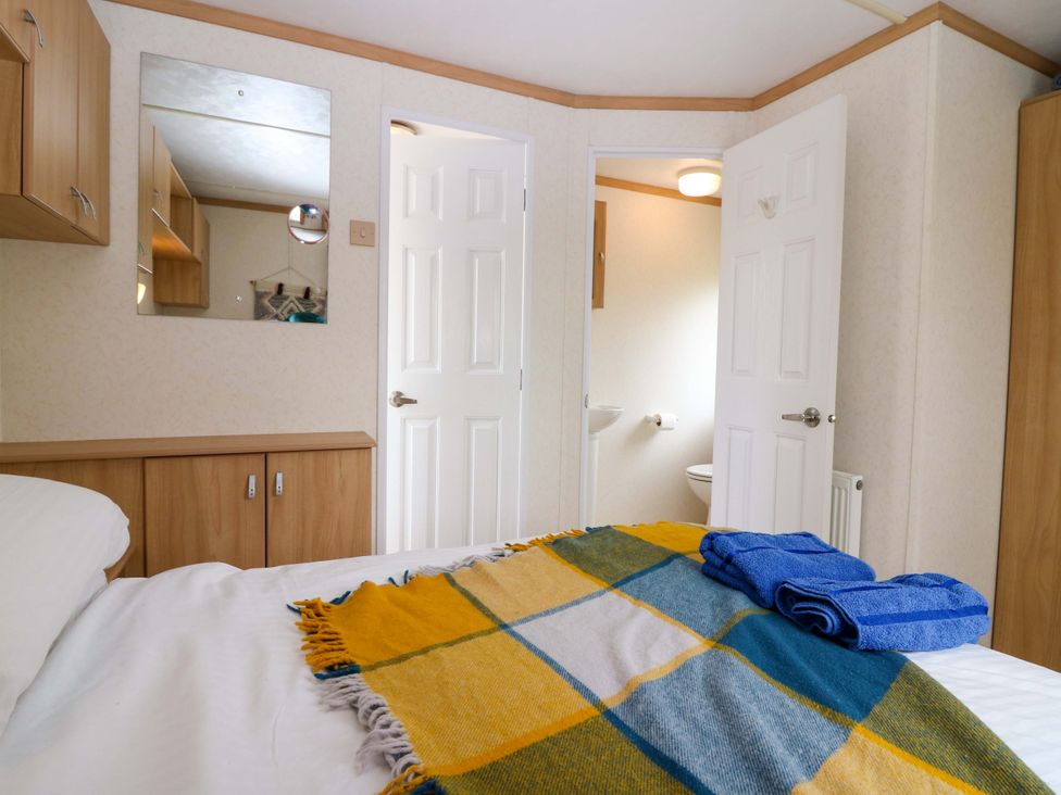 A bedroom with a bed and towels on it at St Monans Holiday Park - Holiday Accommodation 19927, St Monans