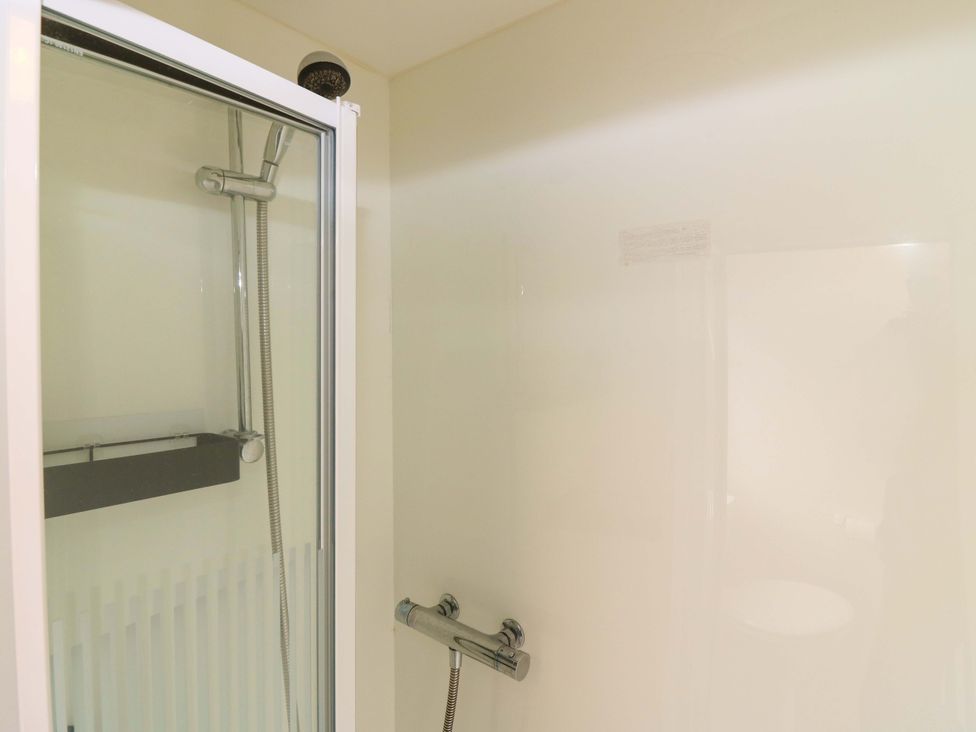 A shower enclosure with a glass door and shower head at St Monans Holiday Park - Holiday Accommodation 19927 St Monans