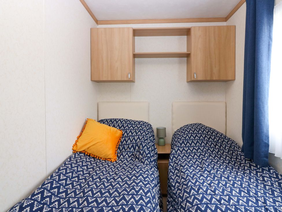 A bedroom with two beds and a shelf at St Monans Holiday Park - Holiday Accommodation 19927 in St Monans