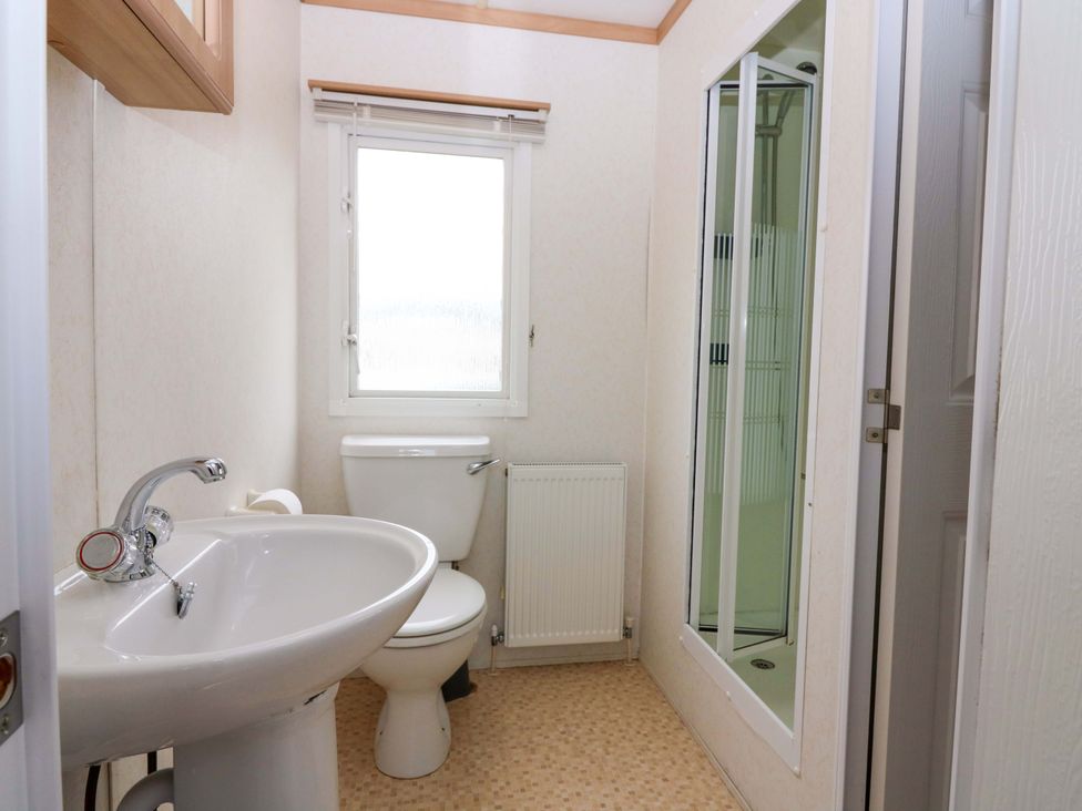 A bathroom with a sink, toilet, shower and window at St Monans Holiday Park - Holiday Accommodation 19927 St Monans