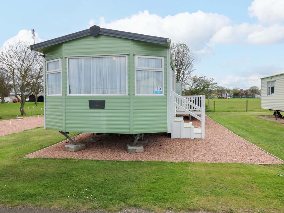 A green caravan with steps and gravel flooring at St Monans Holiday Park - Holiday Accommodation 19927 in St Monans