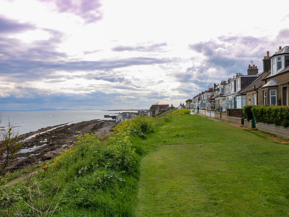 A view of houses by the ocean with grass and rocks at St Monans Holiday Park - Holiday Accommodation 19927 St Monans