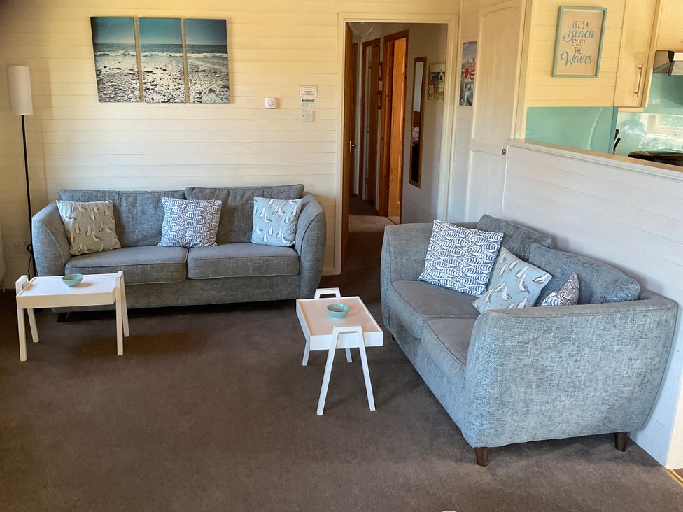A living room with sofas and coffee tables at Lodge 37 Ilfracombe