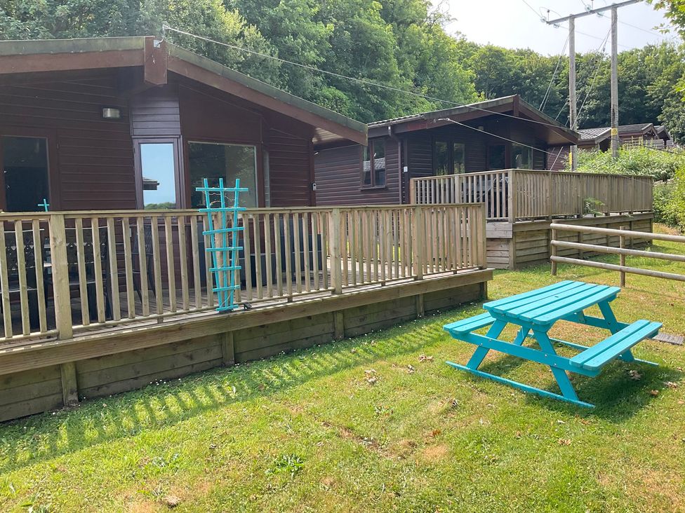 An outdoor area with cabins, a deck, and a picnic table at Lodge 37 in Ilfracombe