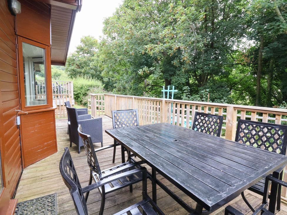 An outdoor patio with a table and chairs at Seagull Lodge in Watermouth near Combe Martin
