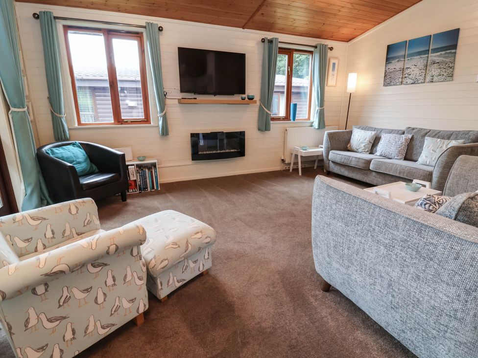 A living room with sofa and armchair at Seagull Lodge Watermouth near Combe Martin