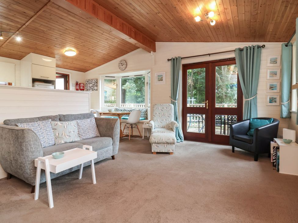 A living room with a couch and dining area at Seagull Lodge Watermouth near Combe Martin