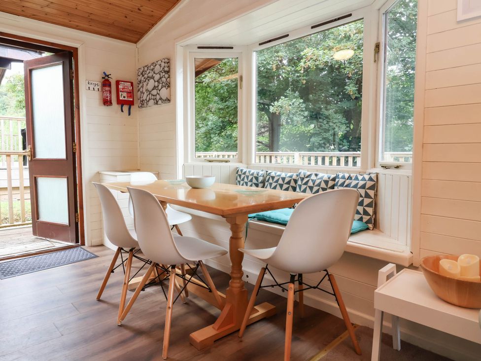 A dining room with a table and chairs at Seagull Lodge Watermouth near Combe Martin