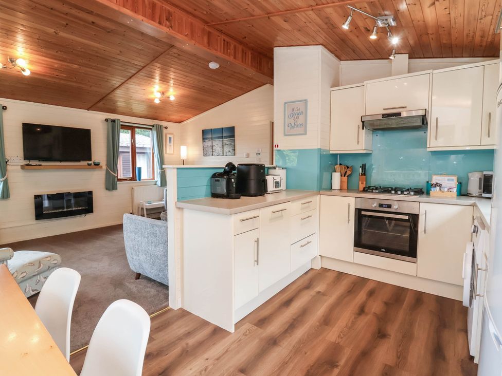 A kitchen with appliances and seating area at Seagull Lodge Watermouth near Combe Martin