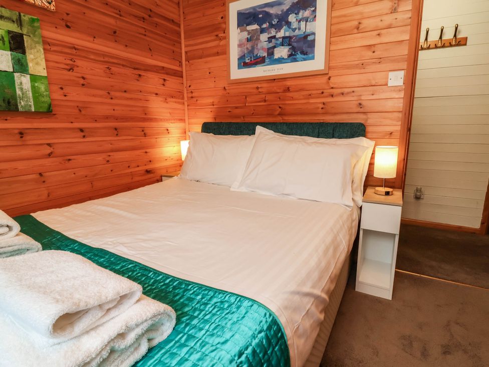 A bedroom with a bed and bedside table at Seagull Lodge Watermouth near Combe Martin