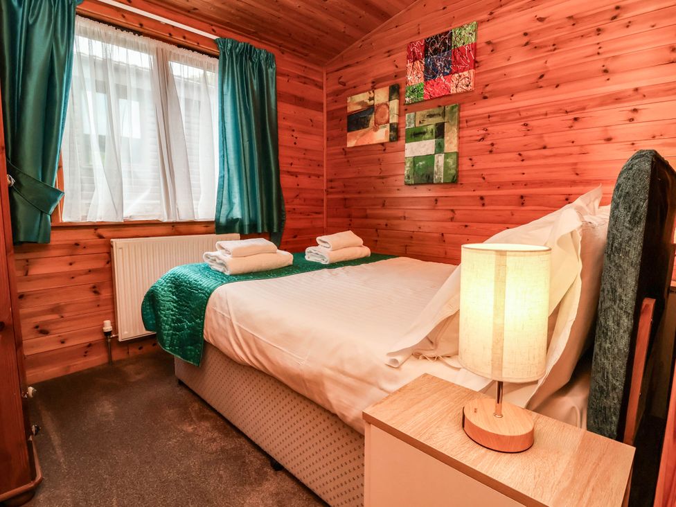 A bedroom with a bed and lamps at Seagull Lodge in Watermouth near Combe Martin