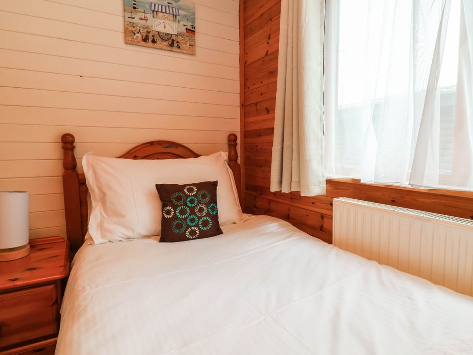 A bedroom with a bed and a window at Seagull Lodge in Watermouth near Combe Martin