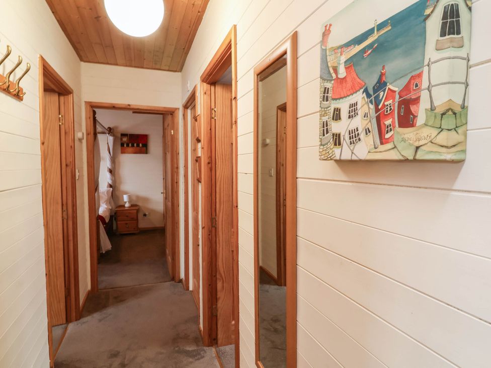 A hallway with doors and wall art at Seagull Lodge Watermouth near Combe Martin