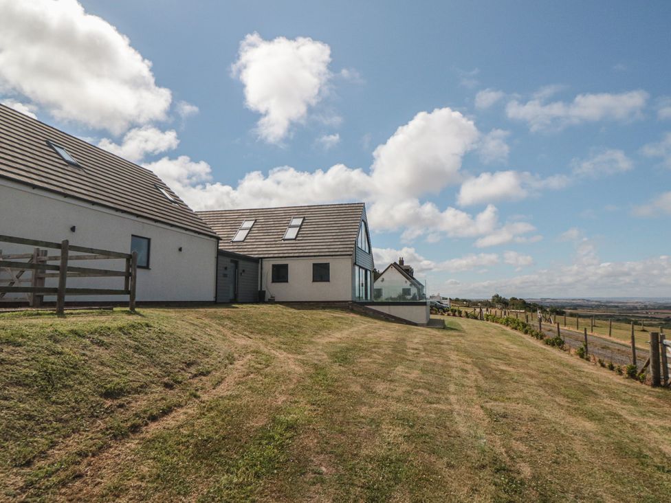 A house with a grassy area and fence at Bay View 