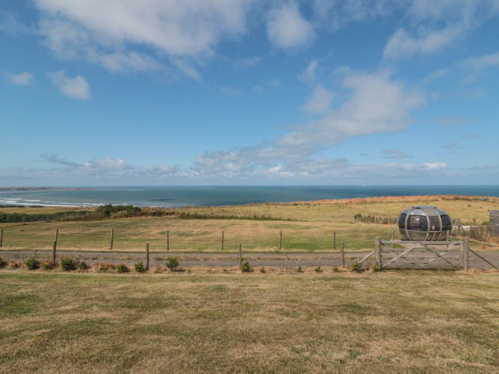 An outdoor area with grass and ocean view at Bay View
