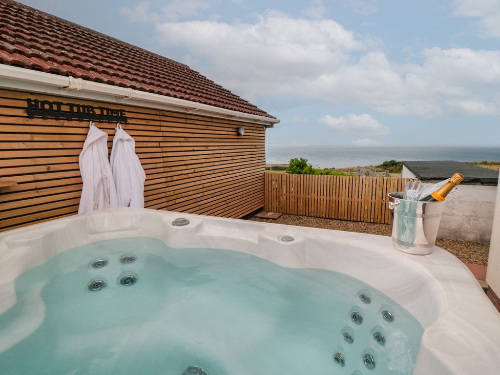 An outdoor hot tub with robes and champagne at Bay View
