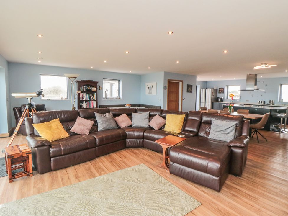 A living room with a sectional sofa and telescope at Bay View