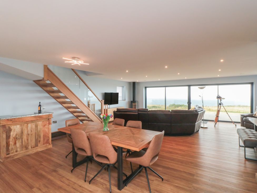 A living room with a dining table and large windows at Bay View