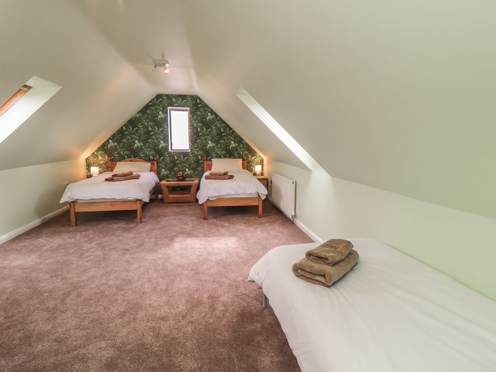 A bedroom with three beds and a nightstand at Bay View