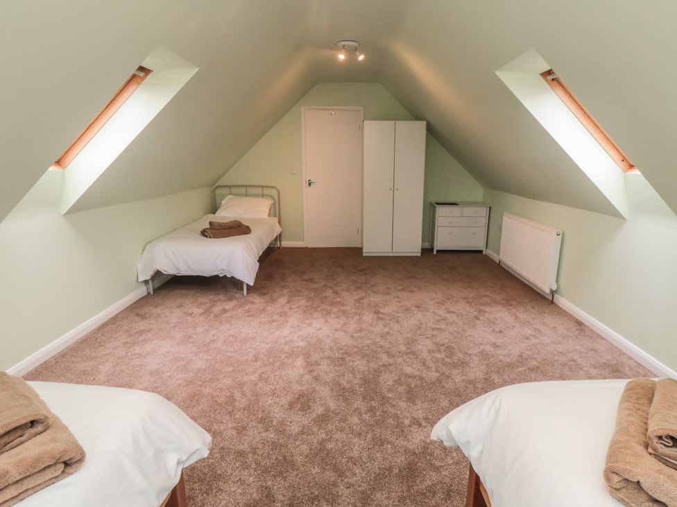 A bedroom with two beds and a wardrobe at Bay View