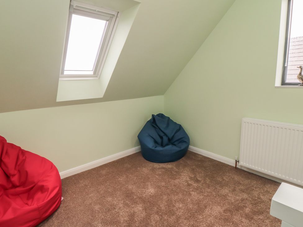 An attic room with bean bag chairs and a window at Bay View