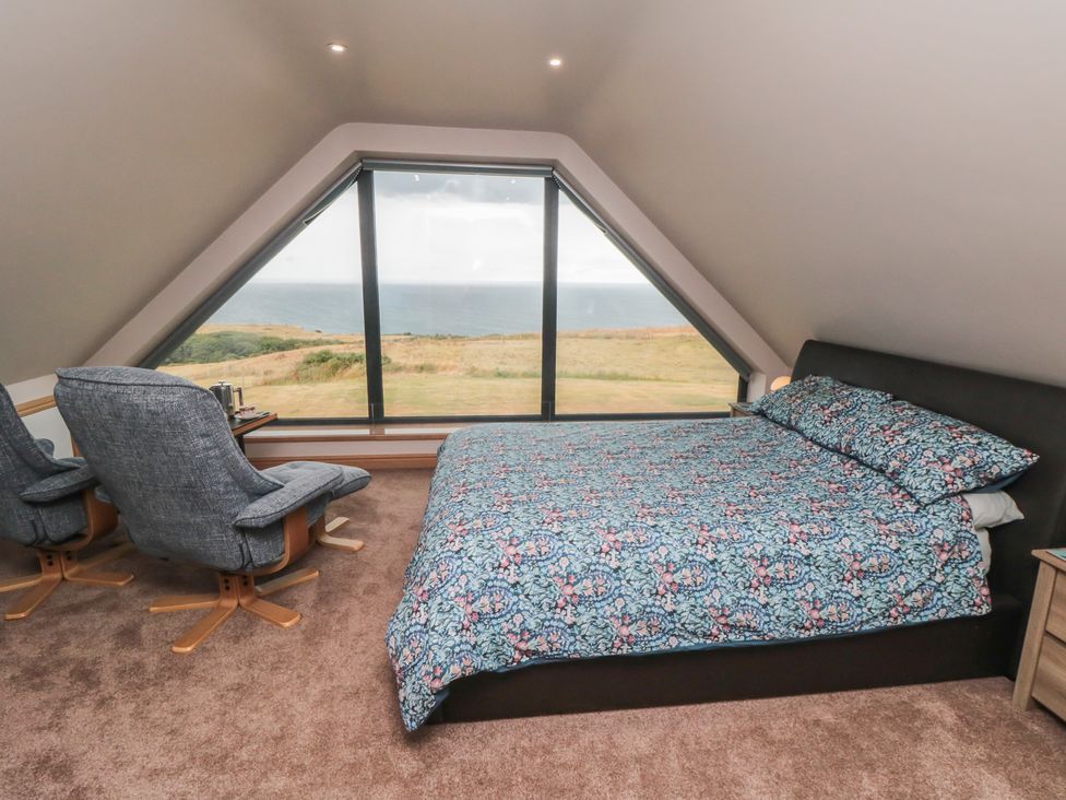 A bedroom with a bed and two chairs at Bay View