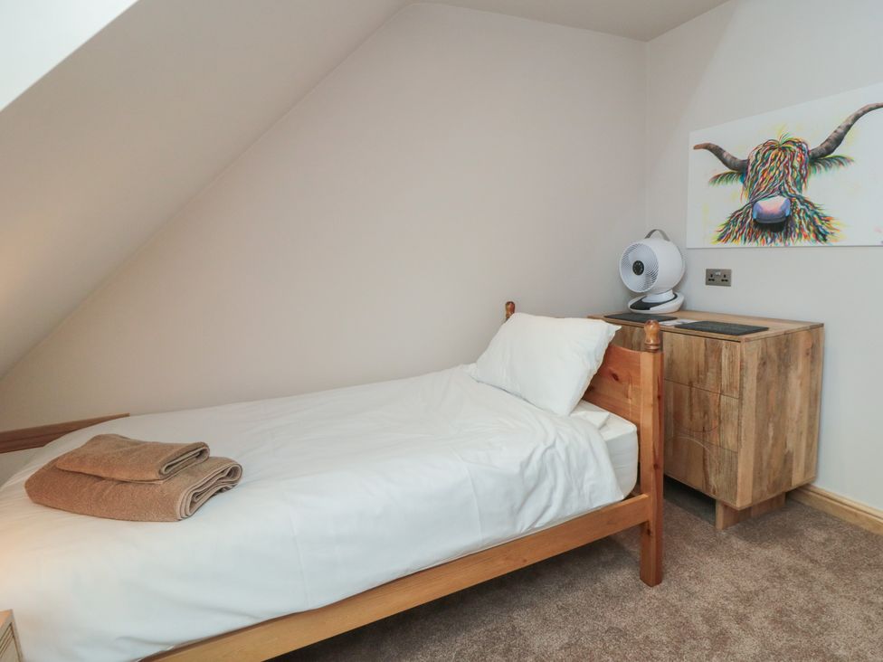 A bedroom with a single bed and a wooden cabinet at Bay View