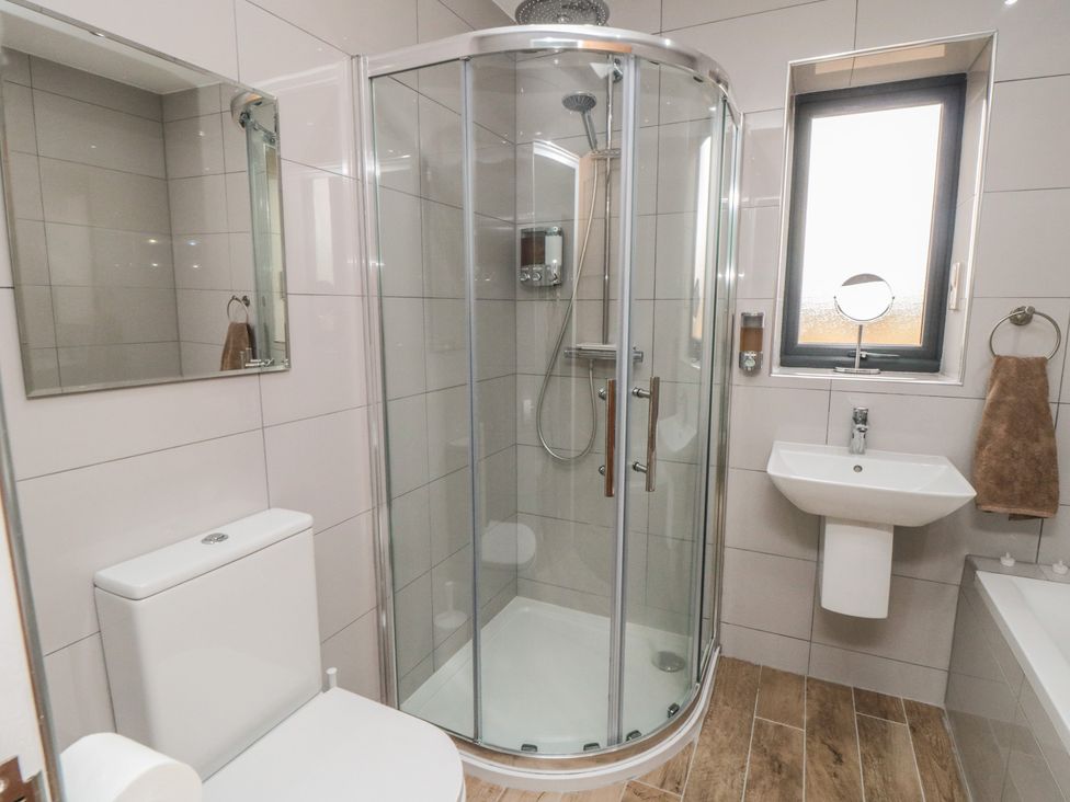 A bathroom with a shower, toilet, and sink at Bay View