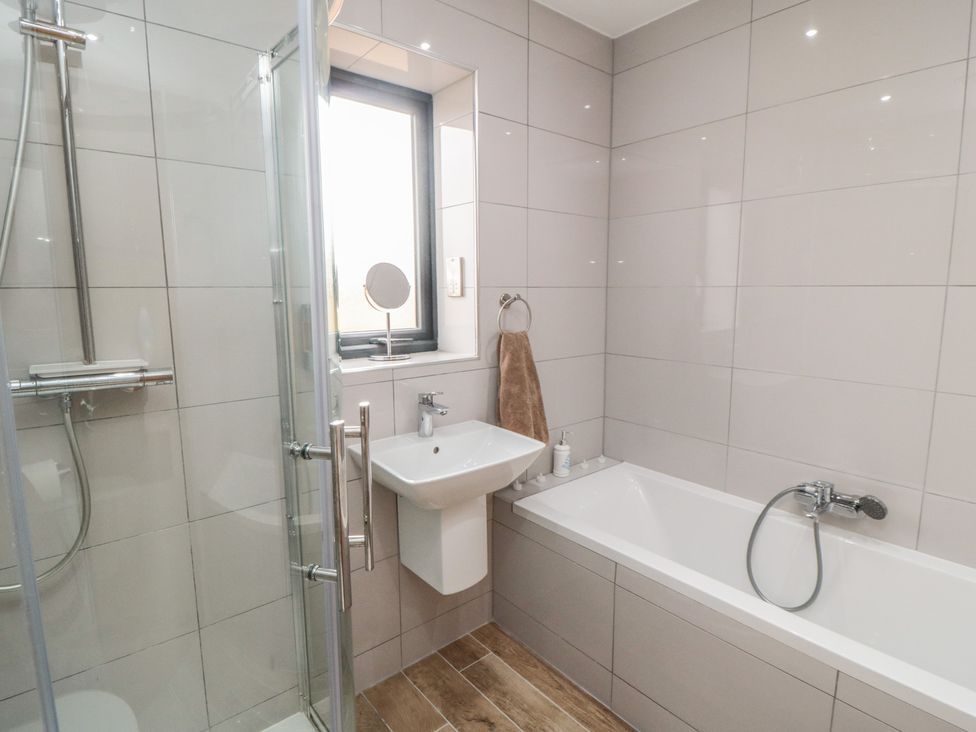 A bathroom with a shower, bath, and sink at Bay View