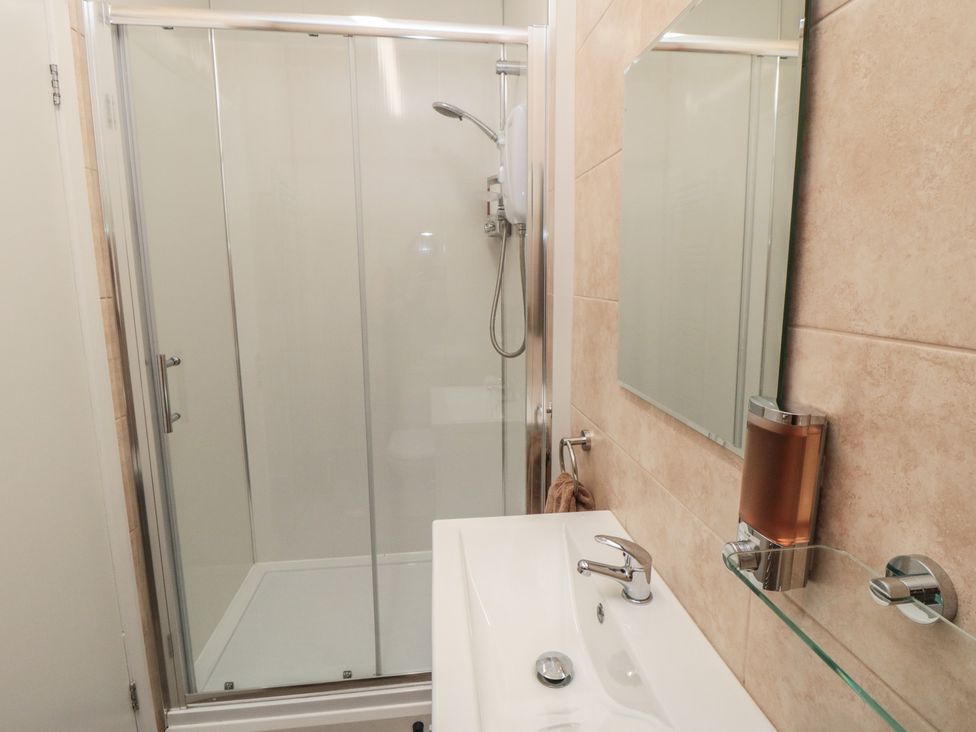 A bathroom with a shower, sink, and mirror at Bay View