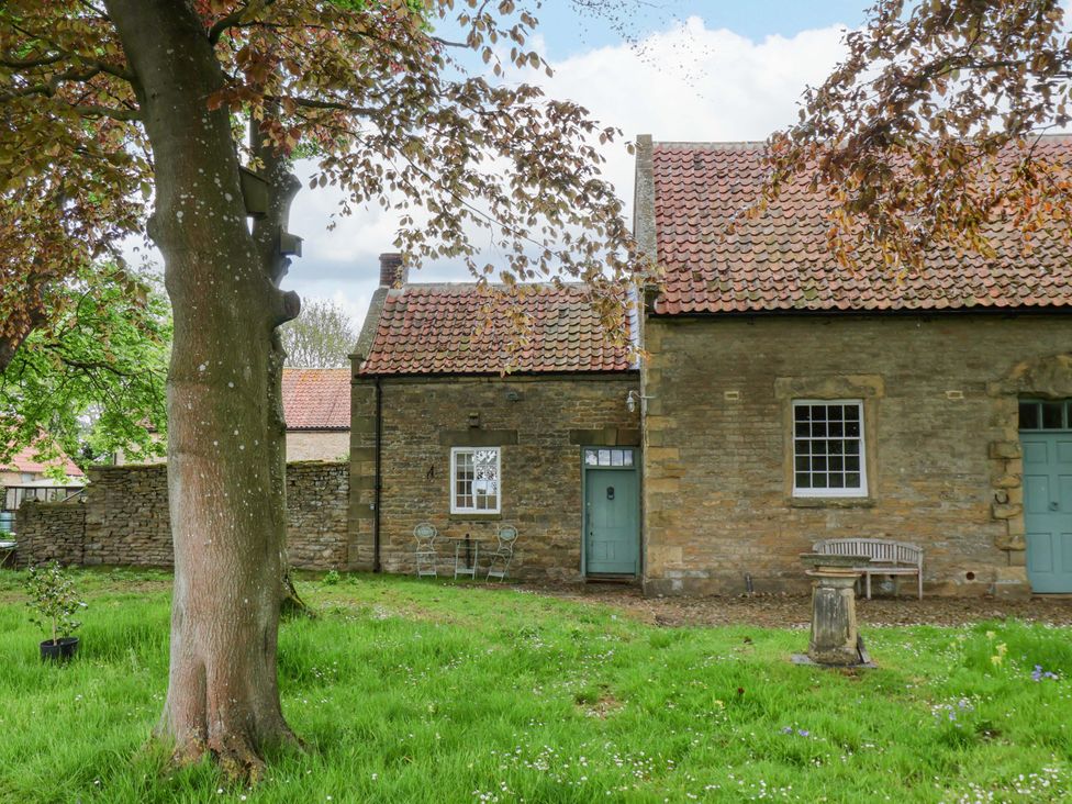 A house with a door and window in a garden at The Gardener's Cottage, Low Hall Scarborough