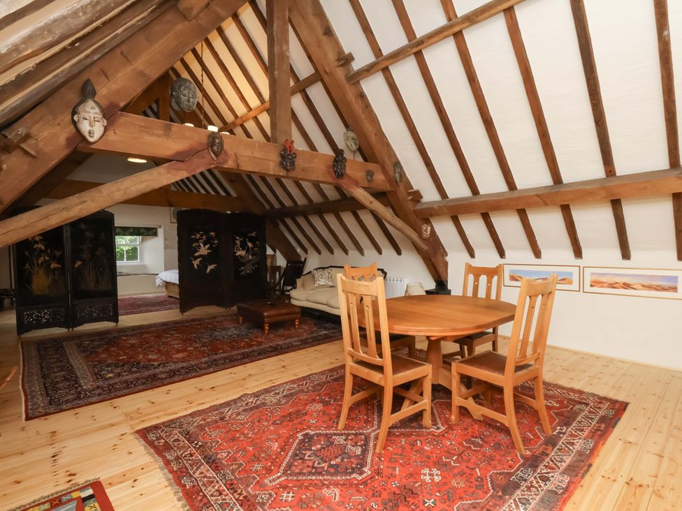 An attic with a dining table and chairs at The Gardener's Cottage, Low Hall, Scarborough