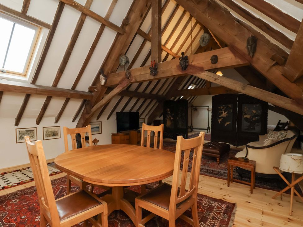 A loft with a table and chairs at The Gardener's Cottage, Low Hall in Scarborough