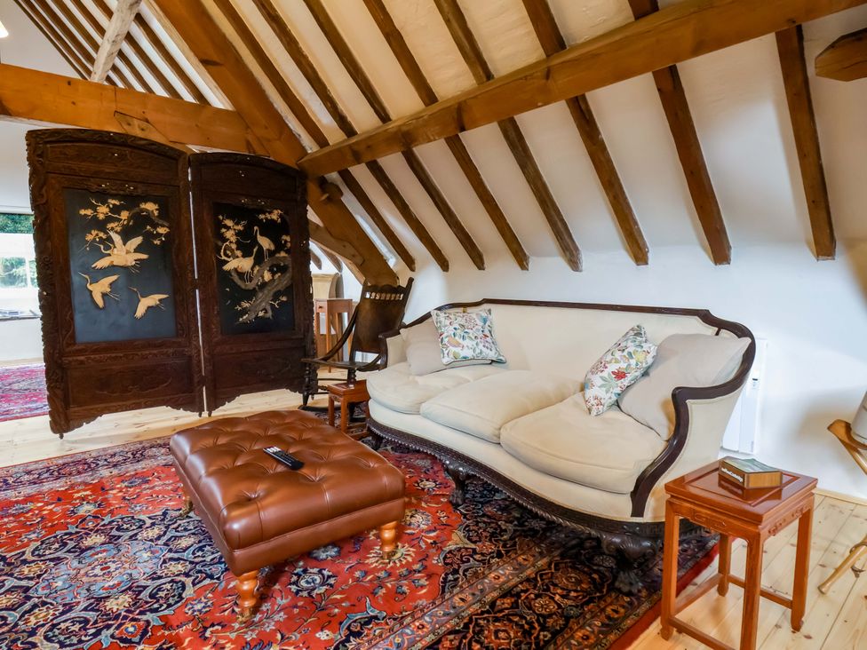 A living room with a sofa and decorative screen at The Gardener's Cottage, Low Hall in Scarborough