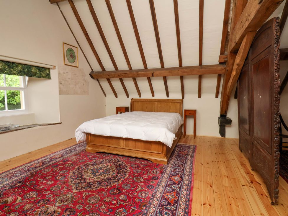 A bedroom with a bed and window at The Gardener's Cottage, Low Hall Scarborough