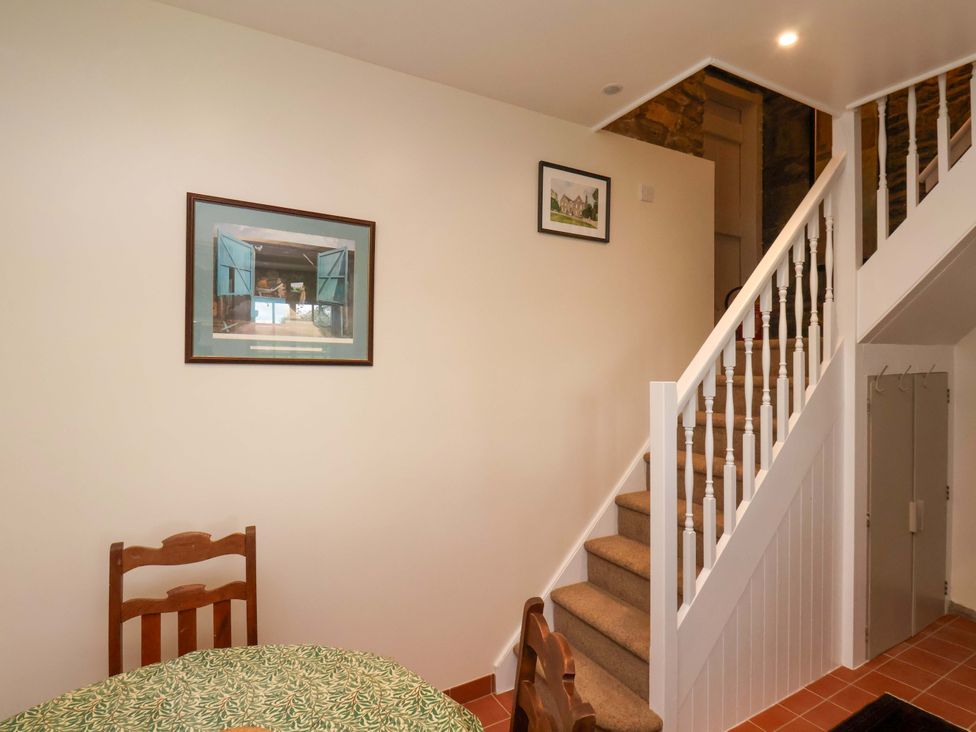 A stairway with a table and chair at The Gardener's Cottage, Low Hall in Scarborough