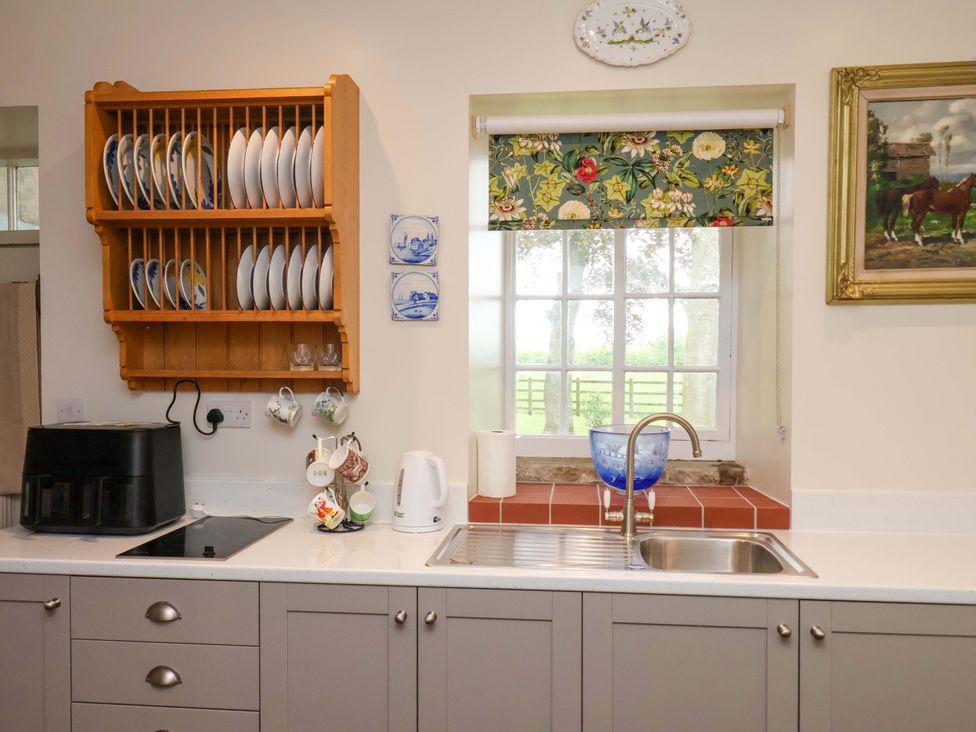 A kitchen with sink and cupboards at The Gardener's Cottage, Low Hall Scarborough
