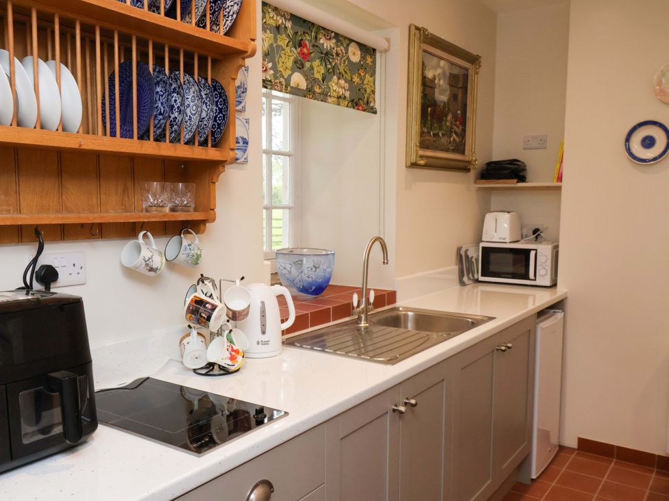 A kitchen featuring a sink, kettle, and microwave at The Gardener's Cottage, Low Hall in Scarborough