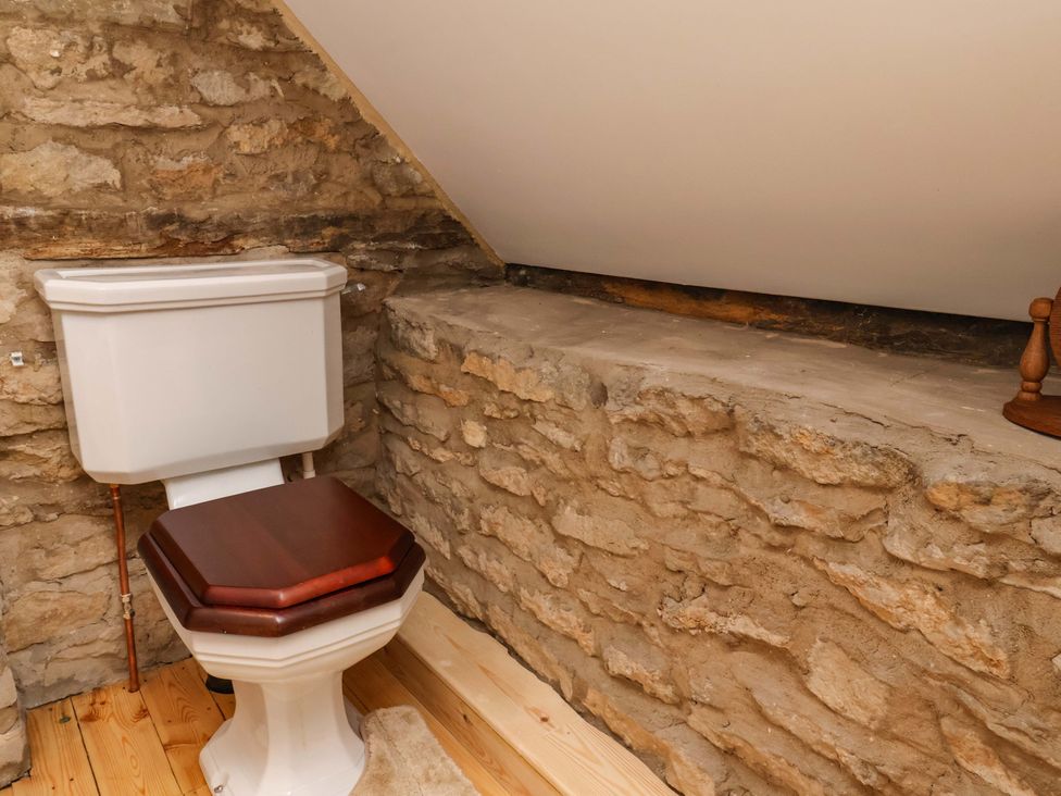 A bathroom containing a toilet and stone wall at The Gardener's Cottage, Low Hall in Scarborough