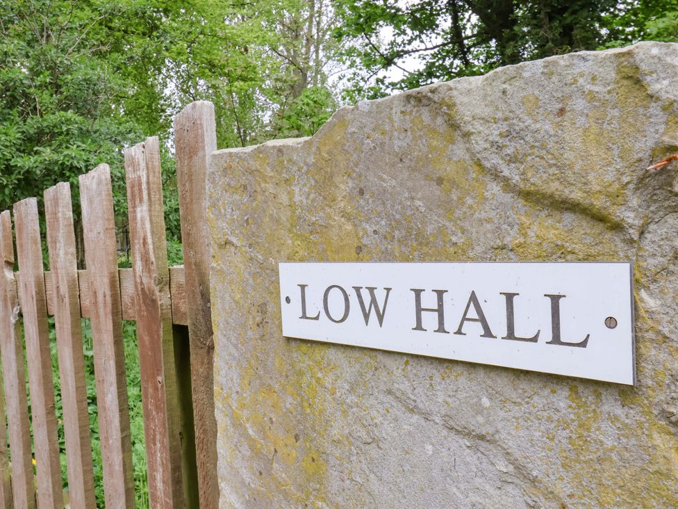 A sign for Low Hall next to a wooden fence at The Gardener's Cottage, Low Hall in Scarborough