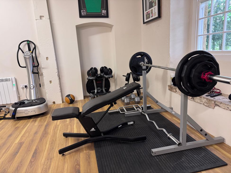 A gym with a weight bench and barbell at The Gardener's Cottage, Low Hall, Brompton-By-Sawdon