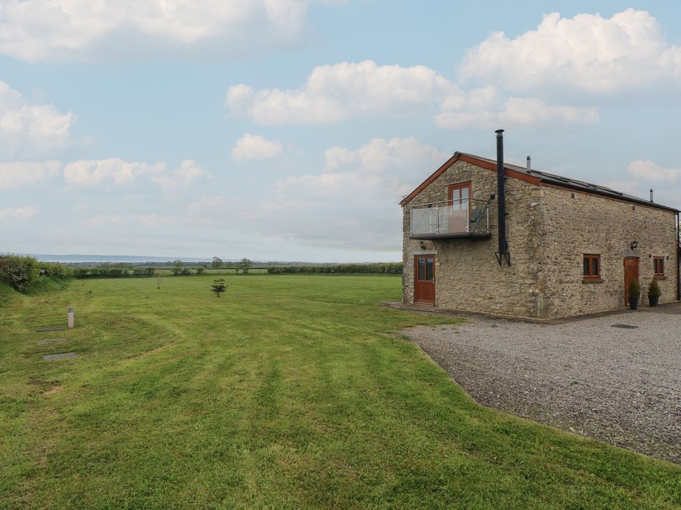 An outdoor area with a stone building and grass at The Gallops in Barry