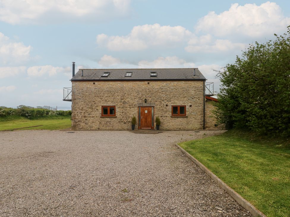 A stone building with a gravel driveway at The Gallops in Barry