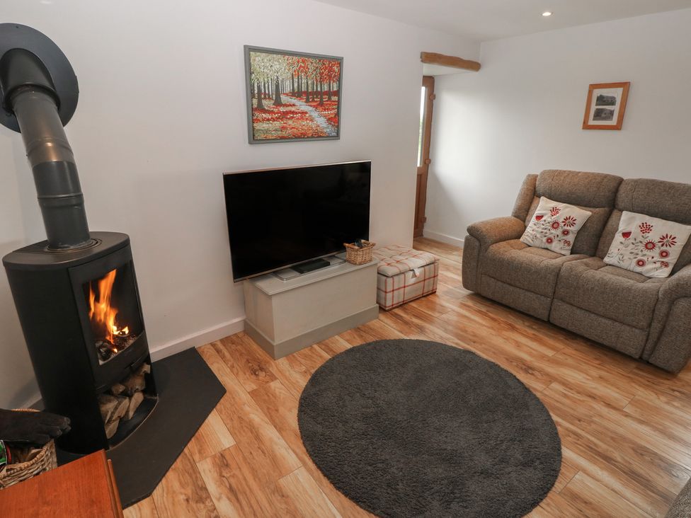 A living room with a fireplace and TV at The Gallops in Barry